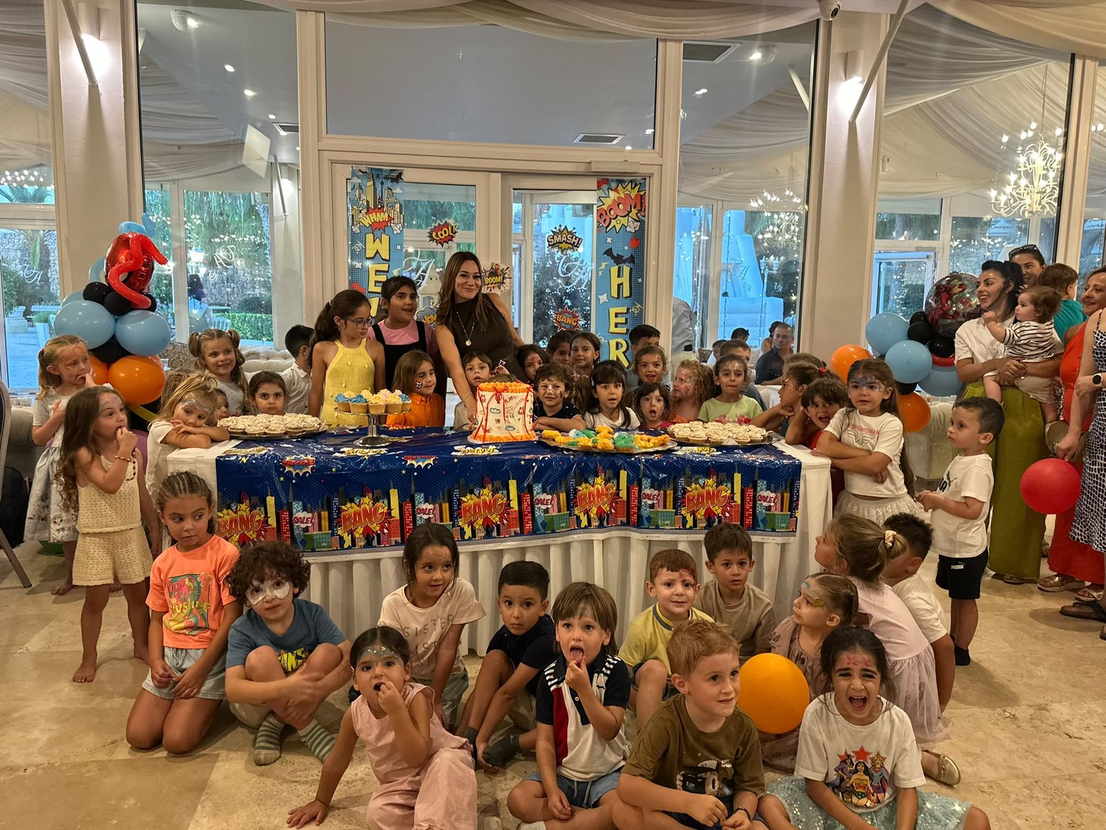 A big group of children around a decorated party table
