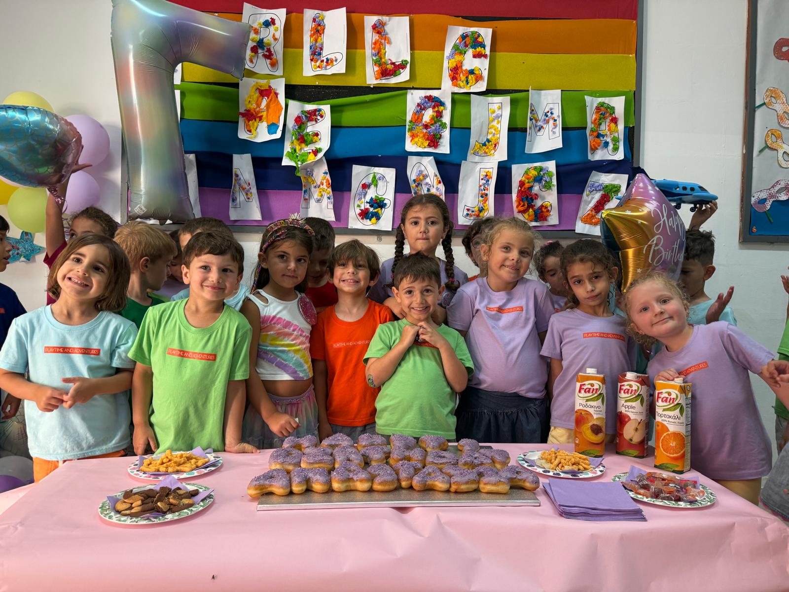 Children in front of a rainbow wall of their own artwork