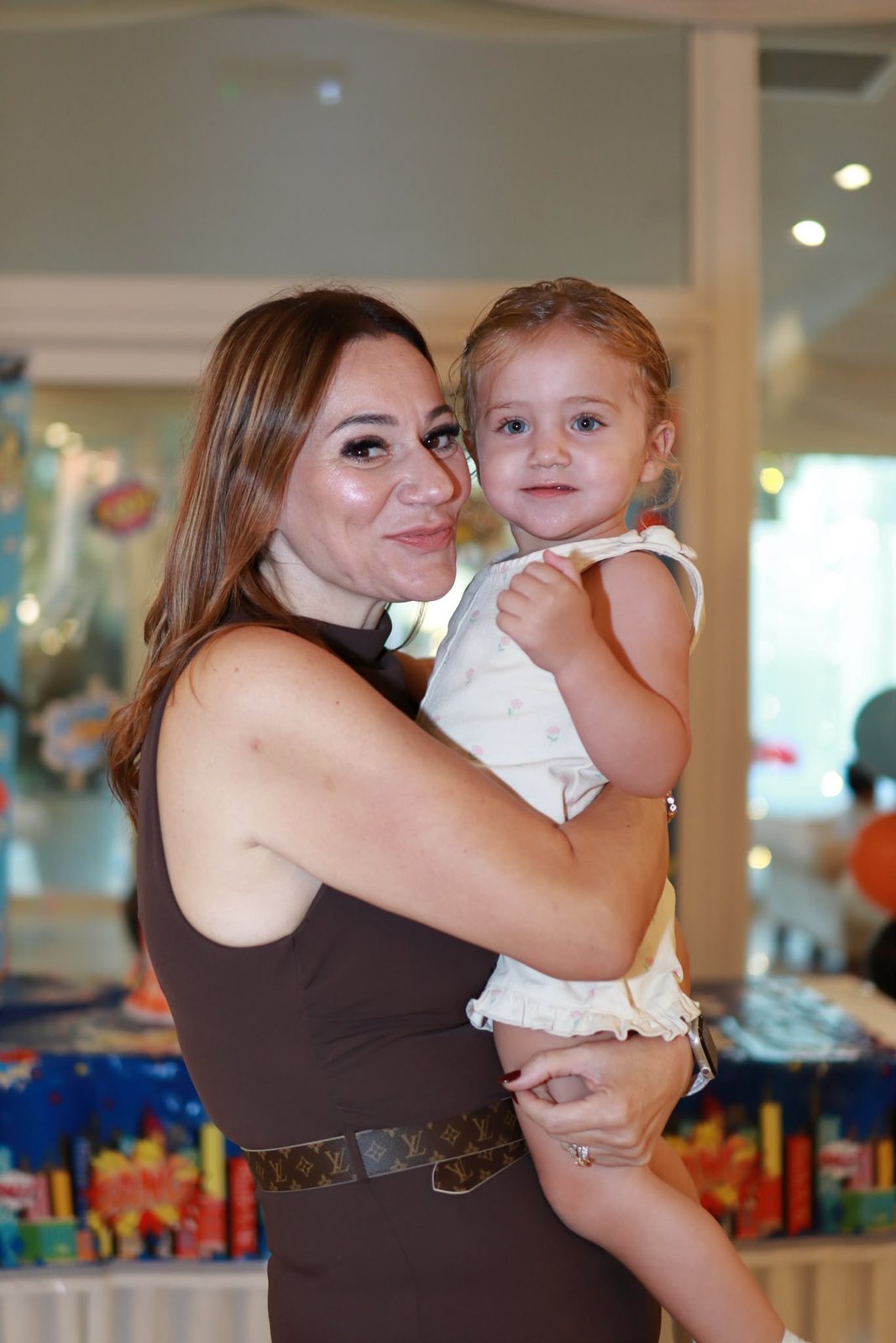 A member of the team holding a smiling toddler