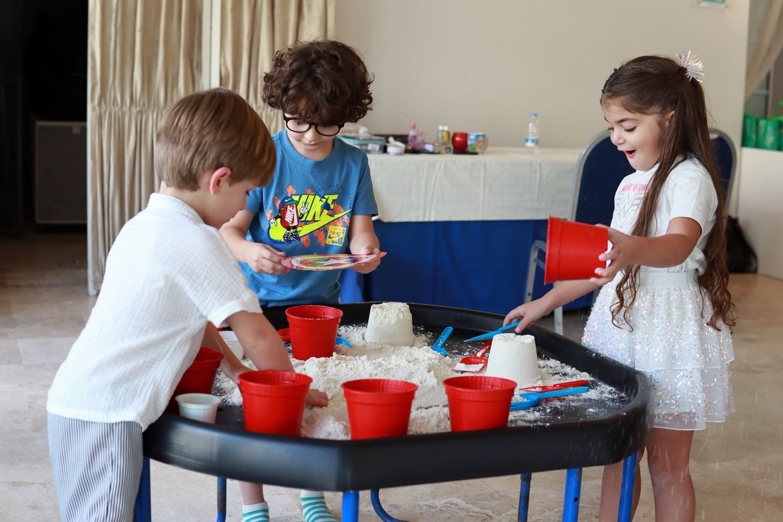 Children scooping water and foam at the water table