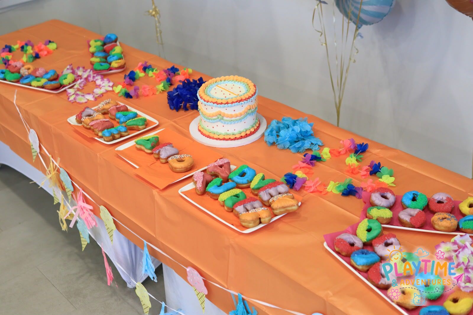 The colourful Summer Party table with doughnuts and garlands