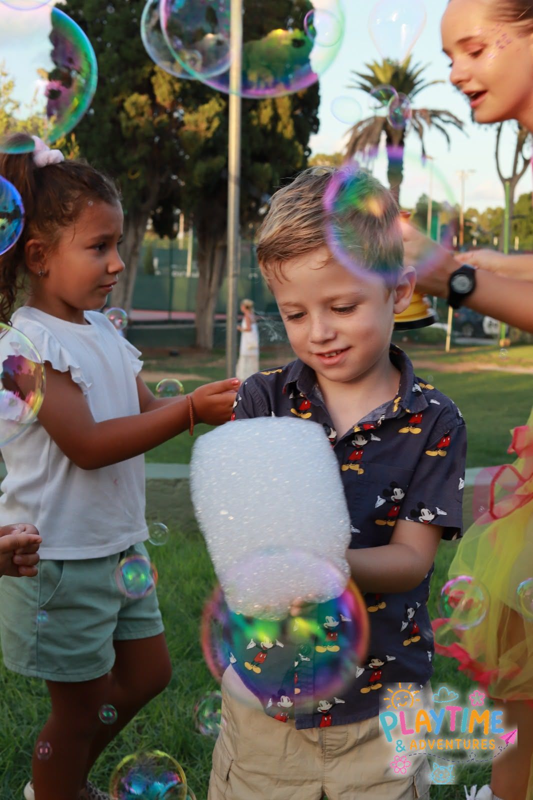 Children playing with giant bubbles and foam
