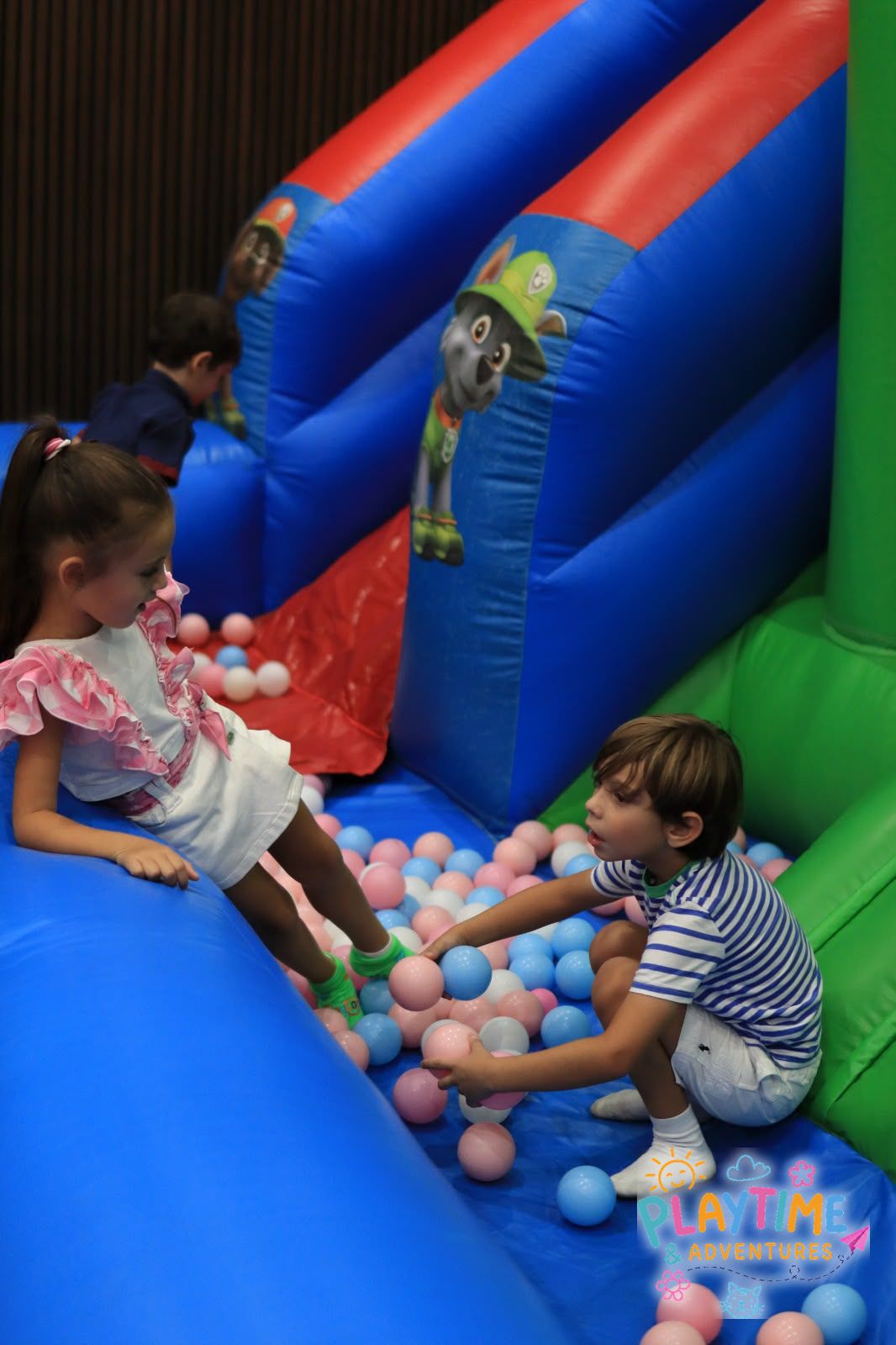 Two children playing in the bouncy castle ball pit